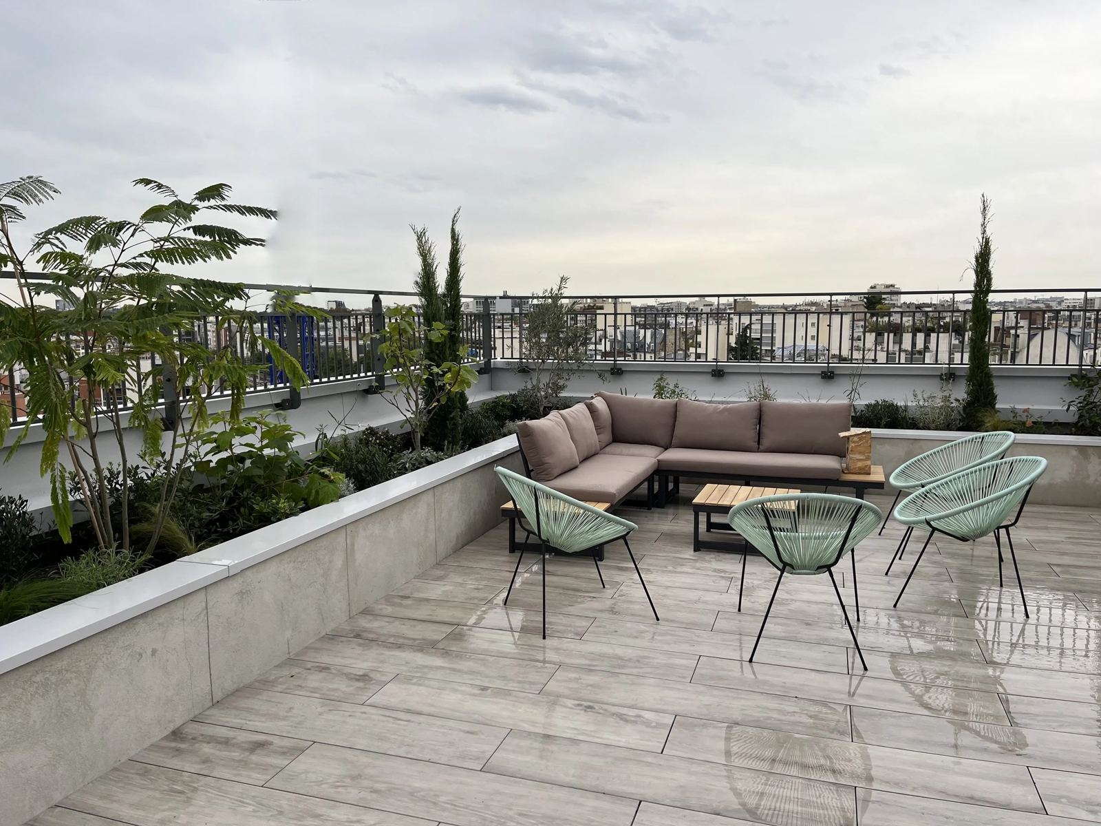 Toit-terrasse de Denfert après les plantations : banquette et jardinières sur fond de toits parisiens